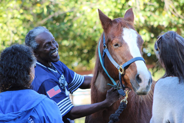 Paula Hertel works with a participant and their caregiver at UC Davis as part of the research for the Connected Horse Program.