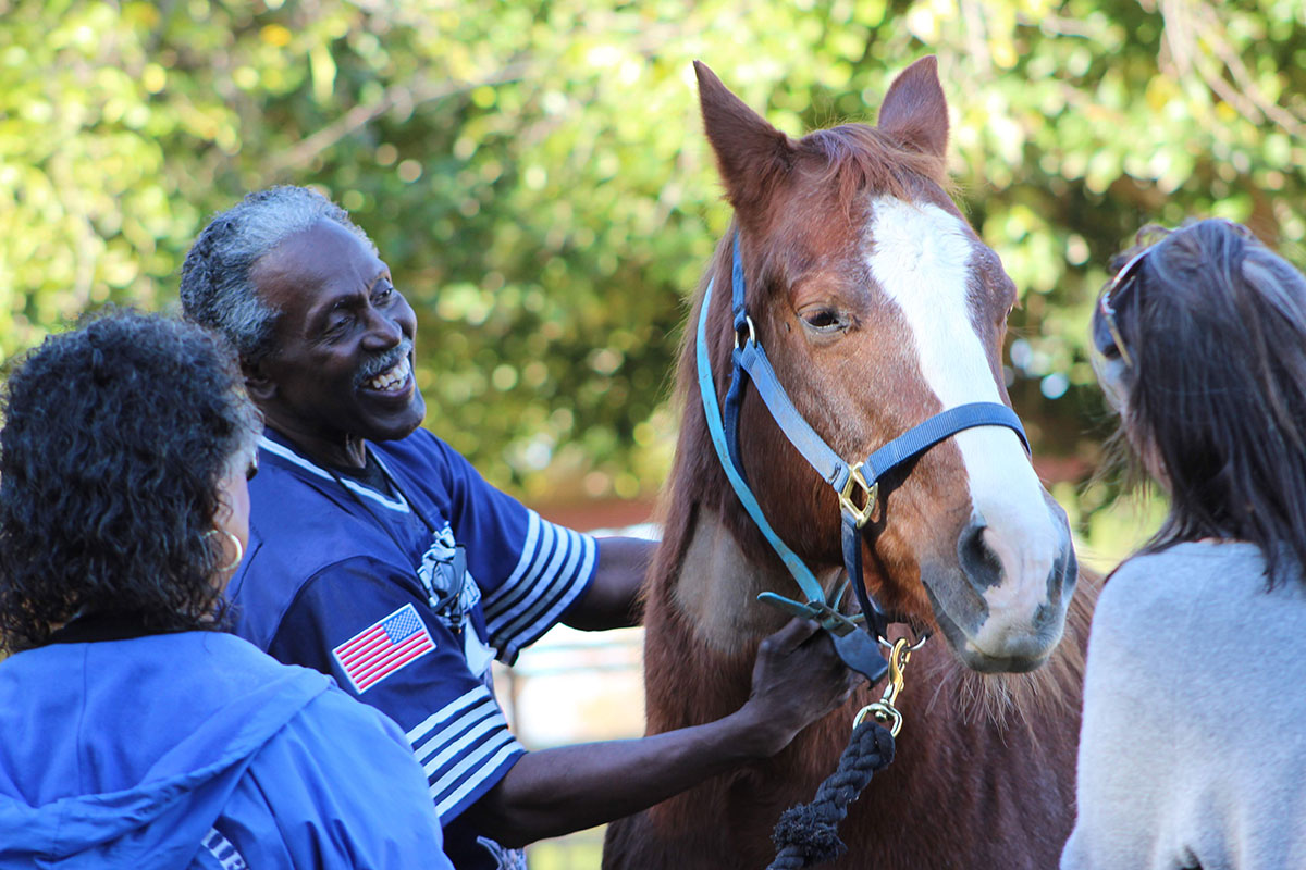 Paula Hertel works with a participant and their caregiver at UC Davis as part of the research for the Connected Horse Program.