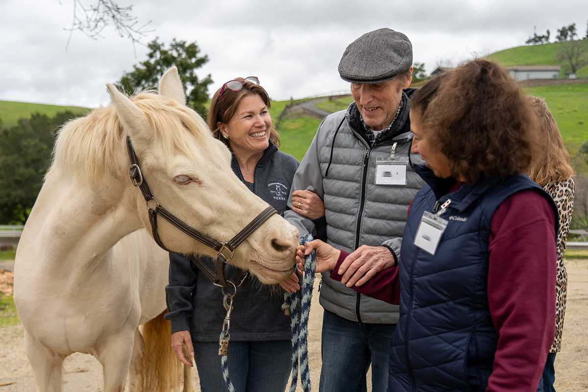 A participant and their care partner, along with founder Paula Hertel, during a workshop at Five Star Equestrian in Pleasanton.